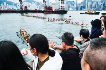 People watch the Hong Kong International Dragon Boat Race to illustrate Hong Kong could lift cap on non-locals