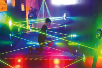 A visitor tries to walk through a security parcour out of laser motion sensors to illustrate HE ties to hacking ‘not surprising’