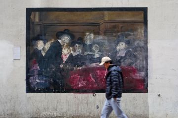 Person walking past a damaged painting in Amsterdam