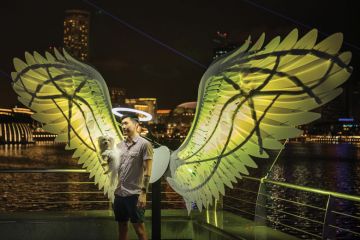 Person being photographed in a light installation in Singapore as the Arts university a milestone for Singapore