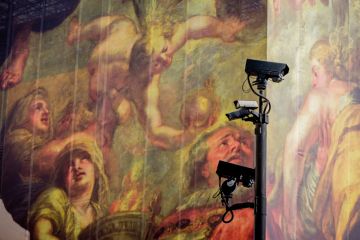 Surveillance cameras keep watch in front of a giant hoarding with classical figures in the background Surveillance cameras keep watch in front of a giant hoarding with classical figures in the background to illustrate report says digital surveillance of scholars ‘erodes faculty freedom’