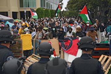 Pro-Palestinian demonstrators confront police as they clear an encampment after students occupied the Physical Sciences Lecture Hall at the University of Californi Pro-Palestinian demonstrators confront police as they clear an encampment after students occupied the Physical Sciences Lecture Hall at the University of California to illustrate Colleges ‘declare war’ on Gaza protest movement ahead of new year