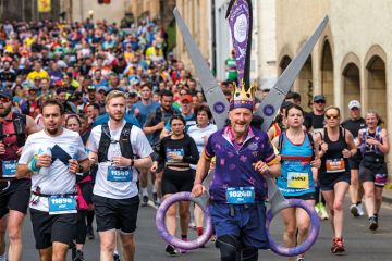 Huge crowd of runners with a charity runner wearing a scissors  fancy dress costume to illustrate ‘£3 billion cut’: inflation analysis reveals loss