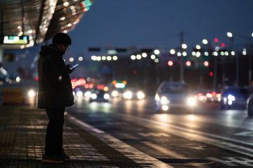 A man uses a smartphone as he waits for a bus at a bus station in Seoul, South Korea to illustrate Korean universities rocked by deepfake pornography scandal