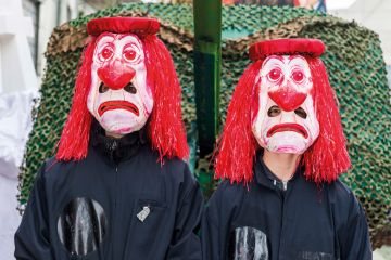 Masked men and women are joining the great procession of Basler Fasnacht to illustrate Switzerland ‘losing attractiveness’ as government limits spending