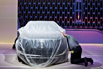 A worker cleans the wheel of a covered vehicle at the Ford Motor Co. Lincoln to illustrate University keeps details of record v-c payout under wraps