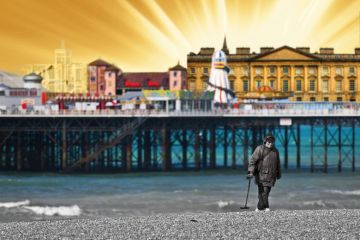 A metal detectorist searching on the shingle beach near Brighton Pier in East Sussex.