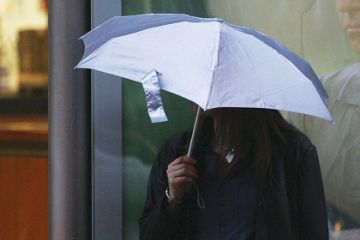 Woman holding umbrella over her head to illustrate Afghan Chevening scholars ‘let down’ by UK universities