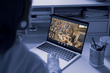 Student looking at laptop, screen has image of a historic painting with men attending a class lecture.