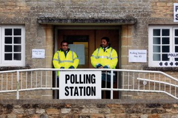 Security staff stand at the polling station to illustrate I’m a bouncer, but don’t ask me to evict students from polling booths