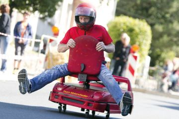 Man racing on an office chair to illustrate Universities must go hybrid to stay relevant, says Coursera CEO