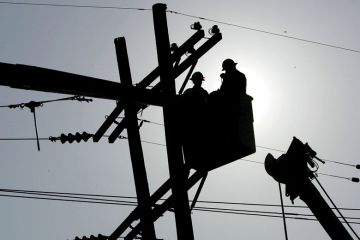 Utility workers repair a power line to show The 10-year programme aims to reshape America’s economy by spending big on transport projects, advanced manufacturing and clean energy.