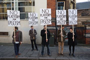 Protesters gather outside Cambridge University's Student Union holding banners reading 'No platform for fascism'