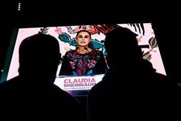 Supporters of Mexico's presidential candidate for Morena party Claudia Sheinbaum look at her on a screen Supporters of Mexico's presidential candidate for Morena party Claudia Sheinbaum look at her on a screen to illustrate Mexican scholars hope for change as scientist takes presidency