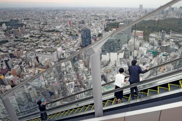 Visitors look out at the view while riding up an escalator at the Shibuya Sky observation deck in Tokyo Visitors look out at the view while riding up an escalator at the Shibuya Sky observation deck in Tokyo to illustrate Students protest as Japanese universities mull tuition fee hikes