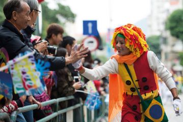 An actor gives a 'hi five' to a spectator in Macao, south China An actor gives a 'hi five' to a spectator in Macao, south China to illustrate ‘We see Macao as a bridge between West and China’