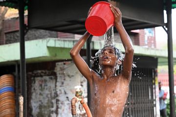 A child is taking a bath from a roadside water pipeline during a heatwave in Dhaka, Bangladesh A child is taking a bath from a roadside water pipeline during a heatwave in Dhaka, Bangladesh