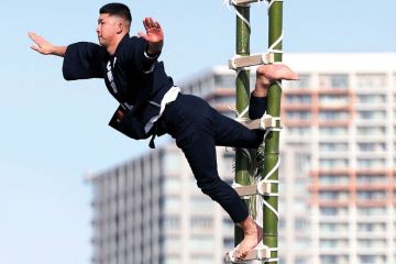 Performer balances on the top of a bamboo ladder to illustrate Japan’s ¥10 trillion excellence fund off to shaky start