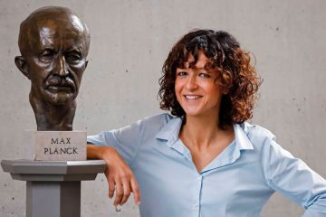 French researcher in Microbiology, Genetics and Biochemistry Emmanuelle Charpentier poses for photographers next to a bust of Max Planck in Berlin as described in the article