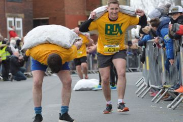 Competitors take part in the World Coal Carrying Championships in Gawthorpe, West Yorkshire to illustrate Staff and students bowed by workloads