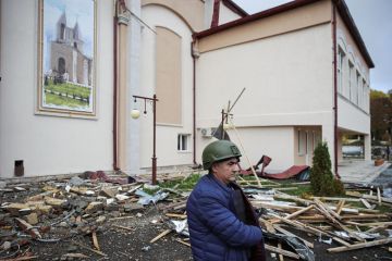 A man stands outside the House of Culture damaged by Azerbaijani military strikes  for Concern over Azerbaijan ruling family influence at Oxford centre