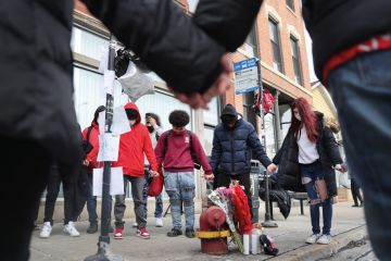 Friends visit visit a memorial for a student who was shot in Chicago, Illinois