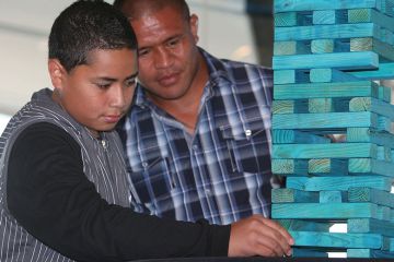 Boy makes a move on a jenga game to illustrate New Zealand mulls introducing base funding for research