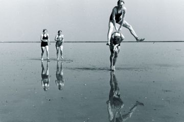 People playing leapfrog on a beach to illustrate ‘Nepotistic’ journals fast-track hyperprolific authors