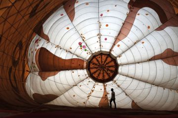  A pilot stretches a hot balloon air as it inflates to illustrate Pakistani universities close temporarily amid soaring inflation