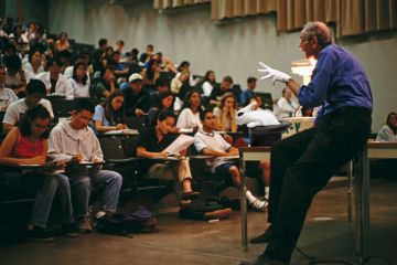 Montage of a professor giving a lecture with a magic glove, hat and white rabbit to illustrate If live lectures die, how will the true magic of shared endeavour be conjured up?