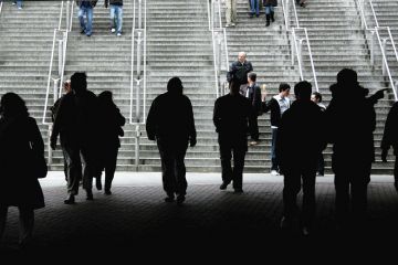 Silhouette of crowd walking towards stairs as a metaphor for more European staff leaving UK for universities abroad post-Brexit