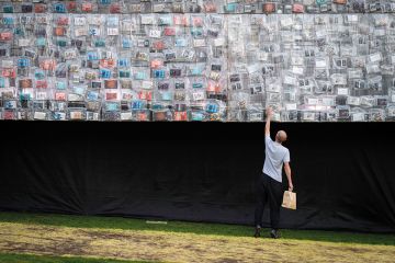 A visitor looks at a book on the side of the Big Ben Lying Down installation to illustrate Forget book deals if REF open access rules proceed, warn scholars