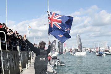 Man, holding a New Zealand national flag, greeting supporters to illustrate Branch campuses ‘not the way forward’ for New Zealand
