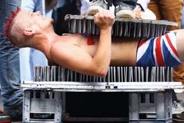A Street entertainer lays down on a bed of nails to illustrate Next generation of humanities scholars ‘imperilled’ by PhD cuts
