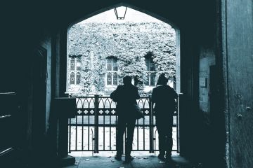 Two People looking over a gated entrance to illustrate Oxford professors ‘forced to retire’ win tribunal case