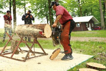 three men saw wood