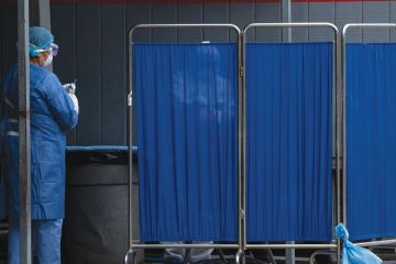 A man is tested behind a screen at the General Hospital 