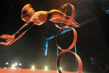Girl jumps threw hoop at circus 