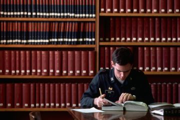 A West Point student reads a book in the library