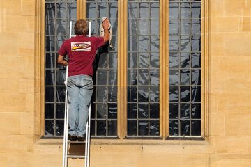 Man cleans the windows of the Bodleian Library