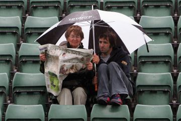 Woman and man read paper in rain