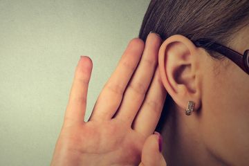 Woman cupping hand to ear to listen