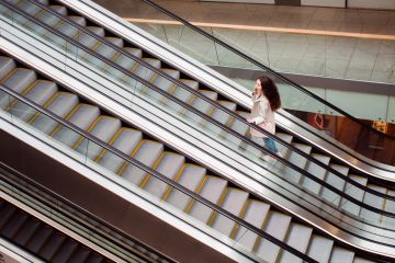 Woman going up on escalator Woman going up on escalator