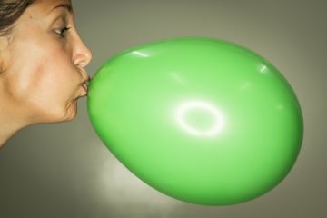 Woman inflating balloon
