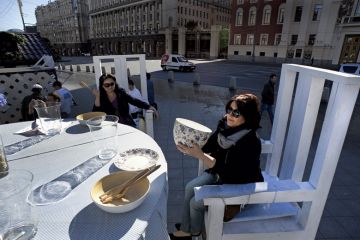 Women sit at giant table Women sitting at giant table