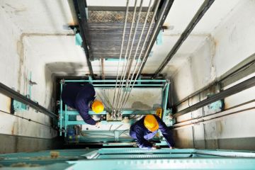 Workmen repairing a lift Workmen repairing a lift