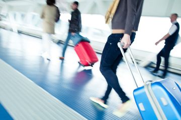 Young male student walking to airport departure lounge Young male student walking to airport departure lounge