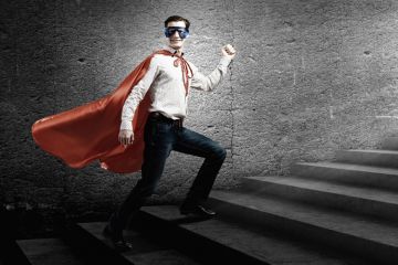 Young man standing on stairs dressed as superhero Young man standing on stairs dressed as superhero