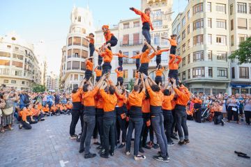 Young members of moixiganga group forming human tower on the street festival in Valencia