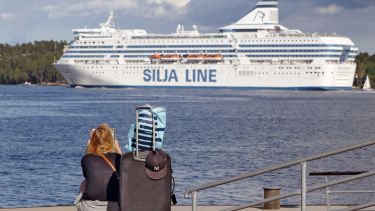 A woman is sitting on the quayside waiting for the boat with her luggage in  Lidingo, Sweden to illustrate Grant deadlines ‘create disparity’
